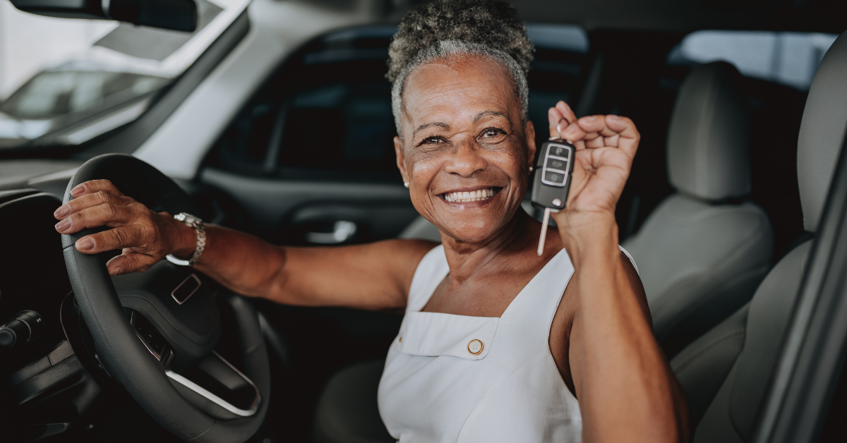 a woman smiling in her car after getting help with negative equity in her car loan
