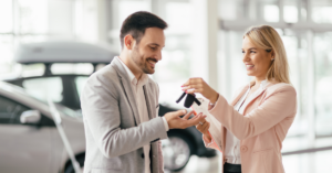 Financing a car with credit challenges. A man and woman swapping car keys during a vehicle purchase